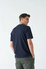 Remera azul marino de hombre con cuello redondo y estampado de montañas en tonos verde, amarillo y blanco.