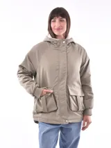 Campera color beige con interior de piel sintética blanca, capucha, cierre frontal con botones a presión, bolsillos laterales con solapa y puños elásticos.