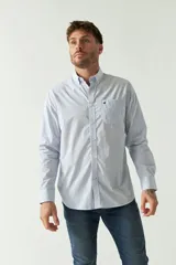 Camisa celeste a rayas rojas de hombre, manga larga, con bolsillo y logo bordado.