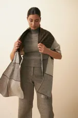 Chal unisex de lana fina sin teñir, realizado con retazos de telas diseñadas por Don Baez. Presenta una grifa de cuero aplicada.