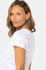 Remera color beige con estampado de flores pequeñas en azul, de cuello redondo y mangas cortas.