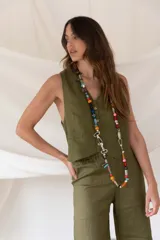Chaleco de lino color verde militar con botones frontales y bolsillos laterales.