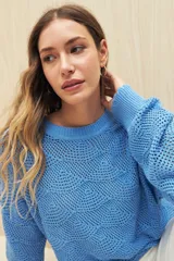 Sweater calado color blanco de punto liviano con diseño geométrico, silueta relajada y terminación en rib en cuello, puños y ruedo.