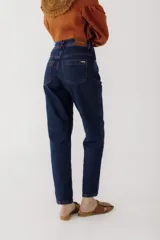 Pantalón de jean azul oscuro, corte mom, con pespuntes rojos y confeccionado en 100% algodón.