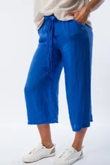 Pantalón capri azul de lino con cintura elastizada y lazo ajustable.