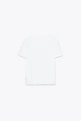 Camiseta blanca de manga corta y cuello redondo con estampado metalizado en el frente.