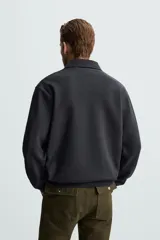 Polo manga larga negro de algodón con elasticidad y estructura. Cuello solapa con cierre frontal de botonadura y acabados con rib.
