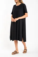 Vestido midi negro de viscosa con elastano, corte recto y mangas cortas.
