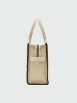 Bolso tote grande Marc Jacobs color beige con estampado del logo de la marca en negro. Tiene doble asa de mano y laterales con inscripción de la marca.