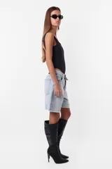 Bermuda de jean celeste con roturas, tiro medio, terminación al corte con pespunte de seguridad, cintura con pasacintos, cartera de cierre y botón metálico personalizado.