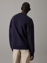 Buzo azul marino de felpa de algodón regenerativo, con cuello redondo, puños y bajo de canalé. Logo mate de Calvin Klein de goma en el pecho.