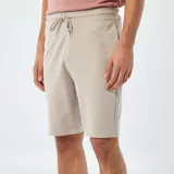 Short deportivo color beige, estilo jogger, con cintura elástica y cordón ajustable.