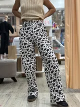 Pantalón largo de denim con estampado animal print de vaca en blanco y negro.