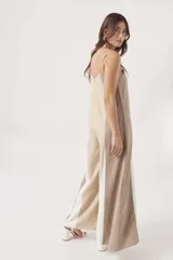 Mono largo de diseño holgado con breteles finos y escote en V. Presenta un diseño tricolor con bloques verticales en beige, negro y blanco.