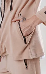 Campera beige con cierre frontal, capucha con cordón ajustable, bolsillos laterales con cierre y calce regular.