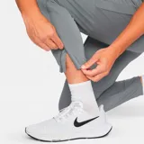 Pantalón largo deportivo Nike Challenger Knit para hombre, color gris con logo blanco en el muslo izquierdo. Corte ajustado con cintura elástica y cordón ajustable. Cuenta con bolsillos laterales y cierres en los tobillos.