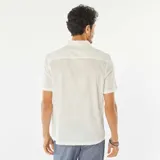 Camisa blanca de manga corta con cuello clásico y estampado de hojas.