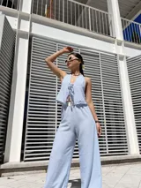 Conjunto celeste a rayas blancas, compuesto por un top halter con volados y un pantalón palazzo con cintura elastizada.