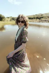 Vestido midi de gasa crepe con estampado floral en tonos verdes y violetas, cuello camisero con detalle de tejido calado y mangas cortas abullonadas.