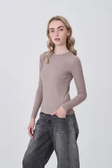 Remera de manga larga ajustada al cuerpo, color negro, con cuello redondo a la base y tejido acanalado.