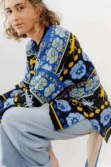 Buzo tejido de jacquard negro con diseños de langostas, flores y formas geométricas en azul y amarillo. Corte oversized con tajos laterales.
