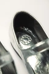 Zapato estilo Mary Jane color marrón, de cuero, con punta redondeada y tira sobre el empeine con hebilla.