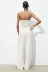 Pantalón de tiro alto color fucsia, con bolsillos delanteros y falsos bolsillos de vivo en la espalda. Tejido con efecto arrugado, pernera recta y cierre frontal con cremallera, botón interior y gancho.