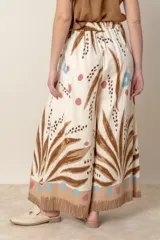 Pantalón palazzo de viscosa color crudo con estampado de hojas y flores en tonos azules y marrones. Cintura elastizada en la parte trasera.
