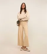 Pantalón wide leg cropped color beige, confeccionado en jeans de cintura media con trabillas, cierre de botón y cremallera, y bolsillos traseros.