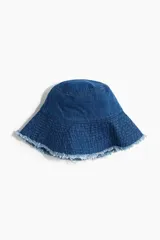 Sombrero tipo bucket de denim azul con ala ancha y terminación desflecada.