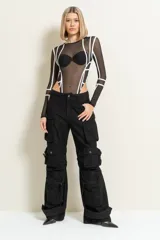 Body negro de malla transparente con líneas geométricas blancas y mangas largas.