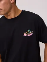 Remera color crema de algodón con estampado en la espalda de un tiburón con gafas de sol, palmeras y texto "Easy life in the City of Palm Rusty 1985".