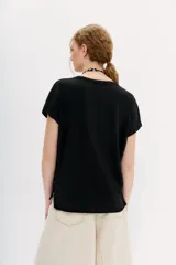 Remera de algodón peruano, color blanco, con escote pronunciado y caída relajada.