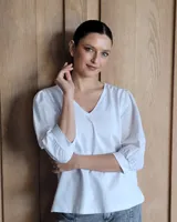 Blusa blanca de mangas 3/4 abullonadas con escote en V.