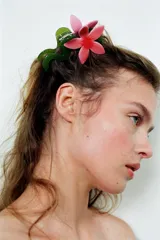 Pinza para el pelo en forma de flor rosa con tallo y hoja verde.