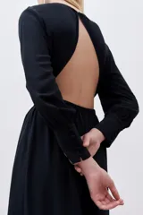Vestido midi negro de viscosa con espalda descubierta, mangas largas y frunces en cintura y cuello.
