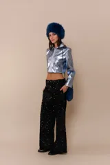 Pantalón negro con detalles brillantes y corte amplio.