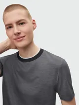 Remera de manga corta color gris con microestampado y cuello redondo con ribete negro y blanco.
