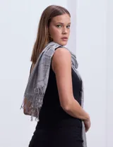 Pashmina gris con diseño a cuadros y flecos en los extremos.