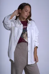 Sobrecamisa negra de gabardina con cuello camisero, cierre frontal con botones, mangas largas con puños abotonados y bolsillos de parche en el pecho.