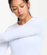 Remera deportiva negra de poliamida con protección UV, mangas largas y corte raglán.