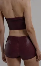 Micro short de cuero sintético color bordó, con cordones cruzados en la parte delantera.