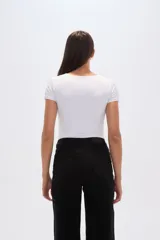 Body de manga corta color blanco, confeccionado en poliamida, de corte ajustado al cuerpo y cuello redondo a la base.