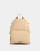 Mochila color beige de tela deportiva con bolsillo frontal con cierre, correas regulables, manija superior, cierre superior y tag de goma.