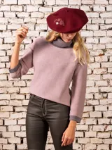 Polera de punto color rosa con cuello alto gris y mangas largas.