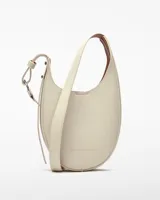 Bandolera pequeña de poliuretano color crema, con textura granulada, un compartimento con cierre magnético, asa larga regulable y logo grabado.