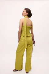 Pantalón recto color amarillo con rayas verticales blancas.