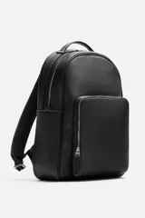 Mochila negra con acabado grabado, compartimento principal con cierre de cremallera, espacio interior para dispositivos electrónicos de hasta 13 pulgadas y bolsillo con cremallera. Bolsillo frontal con cremallera, parte posterior acolchada con banda de sujeción para equipaje, asa de mano y dos asas de hombro ajustables y acolchadas.
