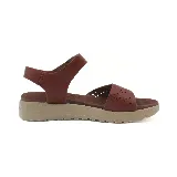 Sandalias bajas color beige con plataforma, tira ancha sobre el empeine con calados y tira con velcro en el tobillo.