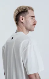 Remera blanca de algodón con corte crop, calce oversize, hombros caídos y cuello redondo.